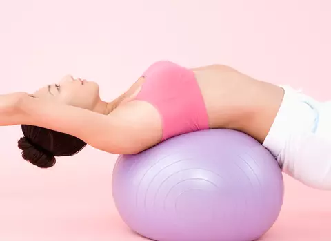 A photo of a woman on a yoga ball