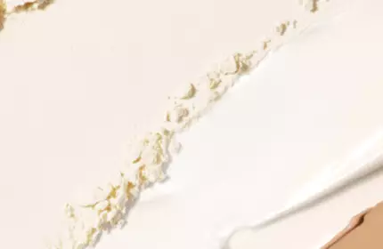 A close-up texture shot of crumbled cream-colored powder.