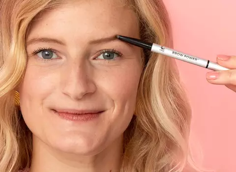 A person filling in their eyebrows with an eyebrow pencil