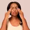 A person rubbing a cleaning balm into their face