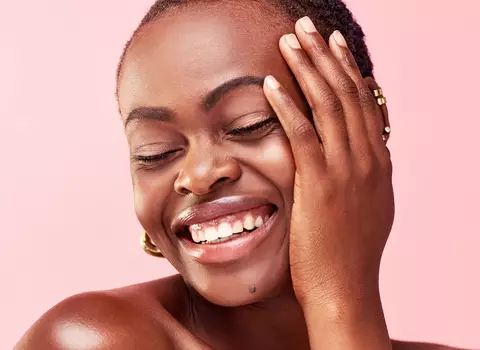 A photo of a brown skin woman smiling