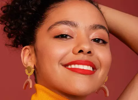 A model smiling wearing IT Cosmetics makeup