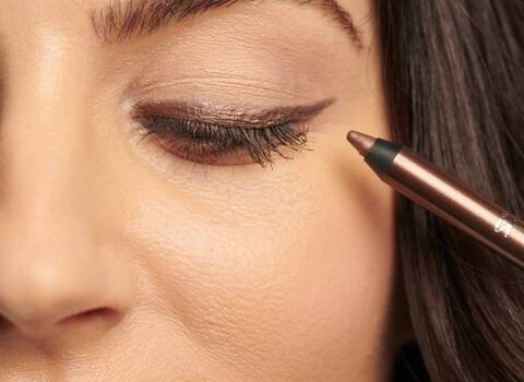 Woman Applying Bronze Eyeliner