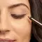 Woman Applying Bronze Eyeliner