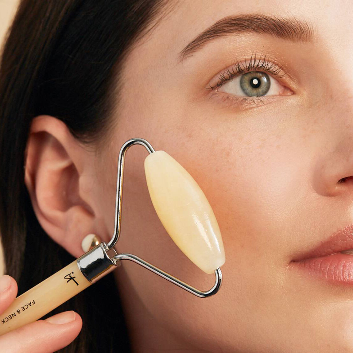 A person using a soothing roller on their face