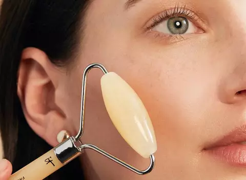 A person using a soothing roller on their face
