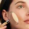 A person using a soothing roller on their face