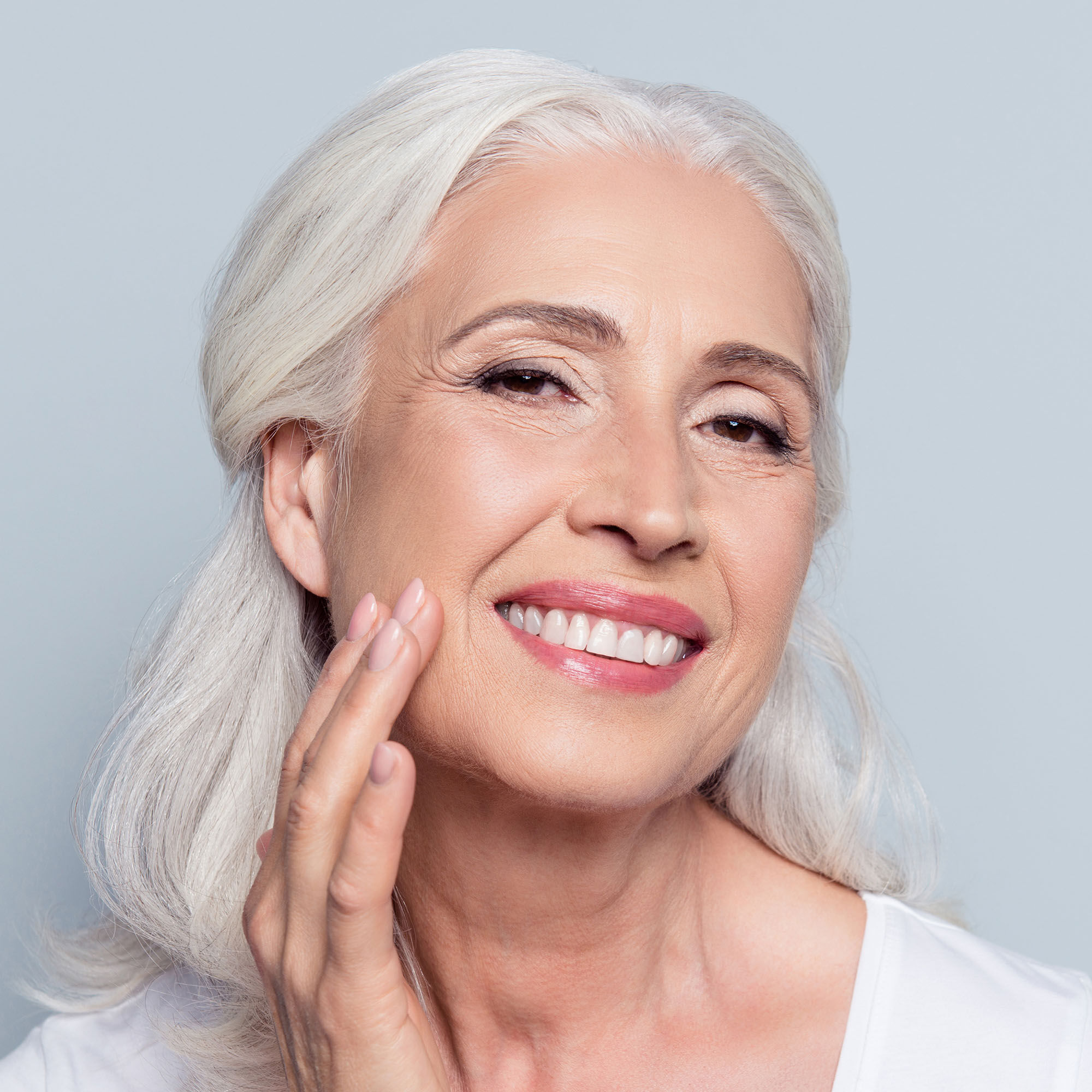 A photo of an older woman touching her face