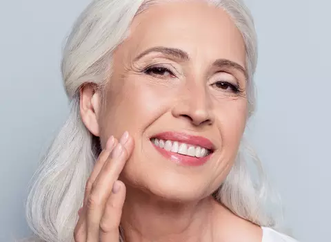 A photo of an older woman touching her face