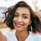 A photo of someone smiling with a lightweight foundation on their face.
