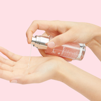 Hands applying pink bottle of Hello Results