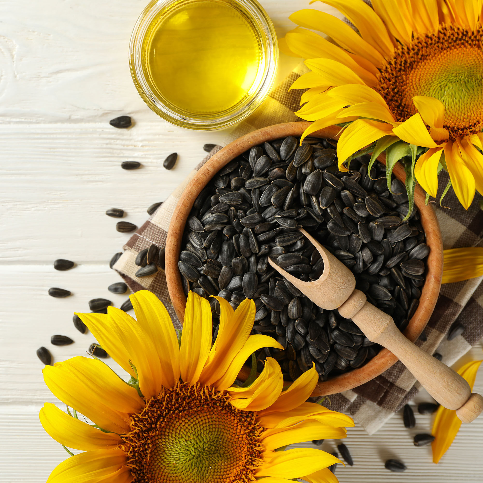 A picture of a bowl of sunflower seeds next to sunflower oil