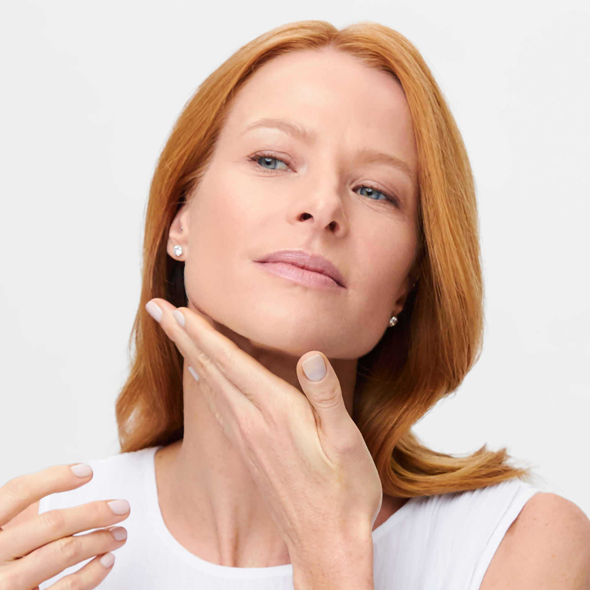 A photo of a woman putting a lotion on her neck
