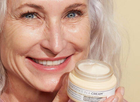 A photo of an older woman with anti-aging cream