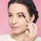 A photo of a woman using an eyebrow pencil