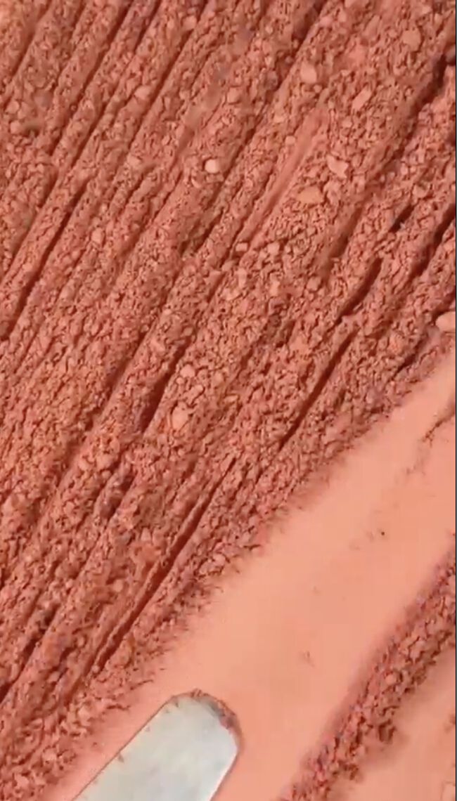 A close-up texture shot of crumbled pink powder.