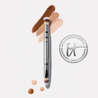 A photo of the IT Cosmetics Heavenly Luxe™ Dual Airbrush Concealer Brush #2 on a white background with swipes of different shades of concealer next to an IT Cosmetics seal.