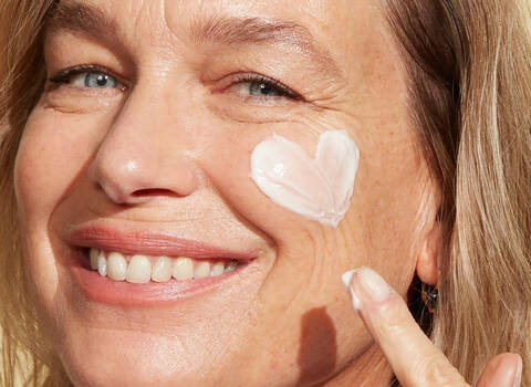 A woman putting face cream on