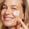 A woman putting face cream on