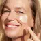 A woman putting face cream on