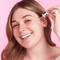 A woman putting a serum on her face