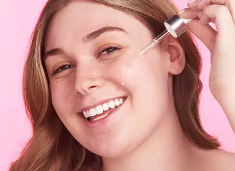 A woman putting a serum on her face
