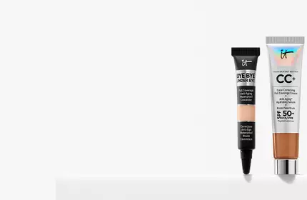 IT Cosmetics Bye Bye Under Eye Concealer and CC+ Full Coverage Foundation with SPF 50+ placed on a white ledge.
