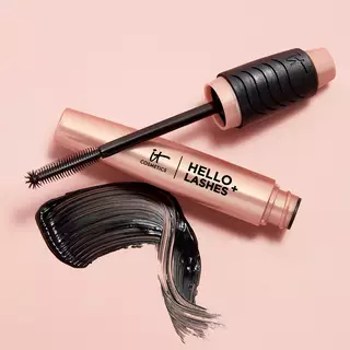An open tube of IT Cosmetics Hello Lashes+ with the mascara brush resting on the tube next to a swipe of black mascara.