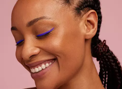 A photo of a woman with blue eyeliner and braids