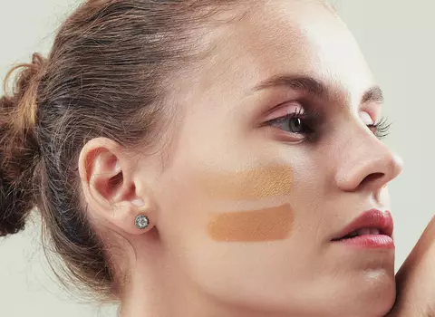 A photo of a woman with a light cream under her eyes