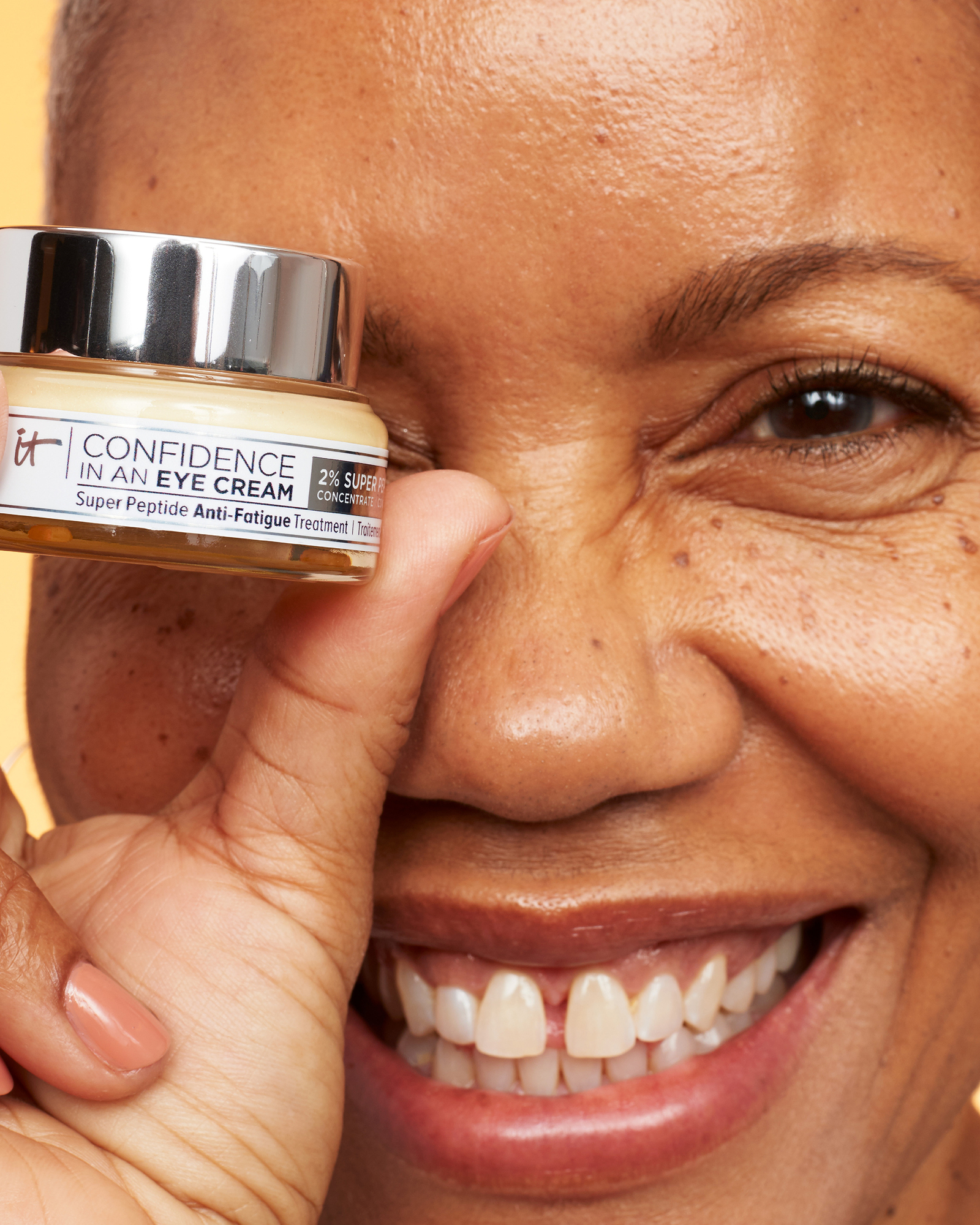 An older woman holding Confidence in an Eye Cream Anti-Aging Peptide Eye Cream and smiling